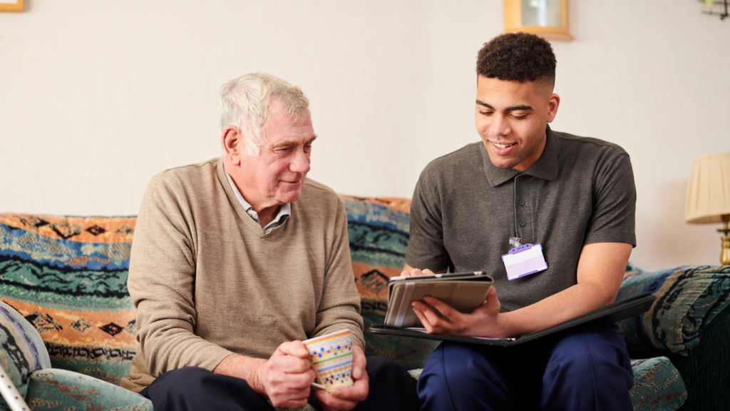 Young man showing ipad with care plan notes to old man