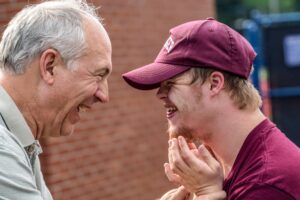 A man and boy smiling and laughing at each other